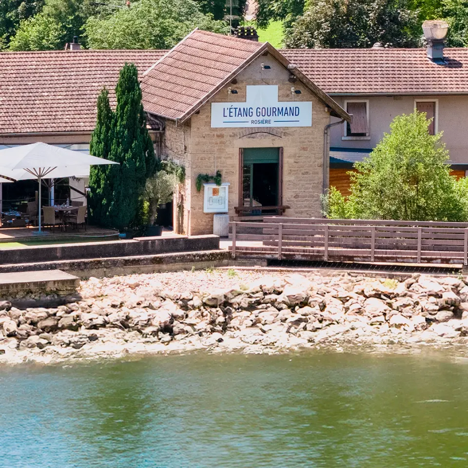 Façade en pierre de L’Étang Gourmand, ancien moulin au bord de l’eau