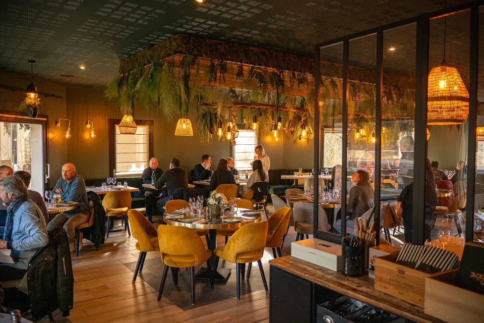 La salle du restaurant Rosière, ses suspensions végétales et ses fauteuils moutarde